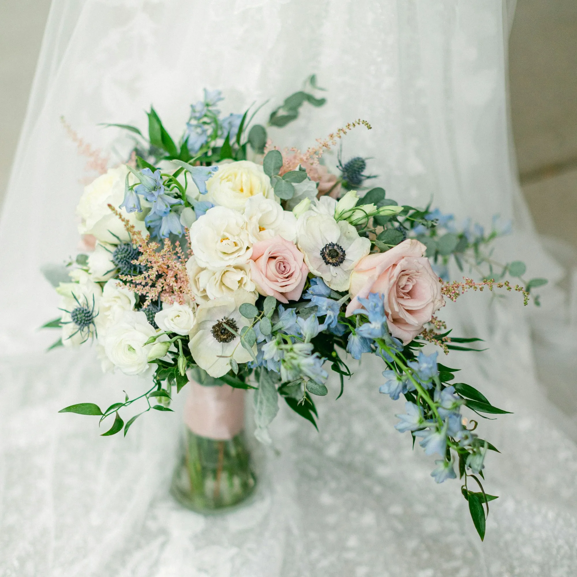 Bridal bouquet of white and blush flowers on a veil