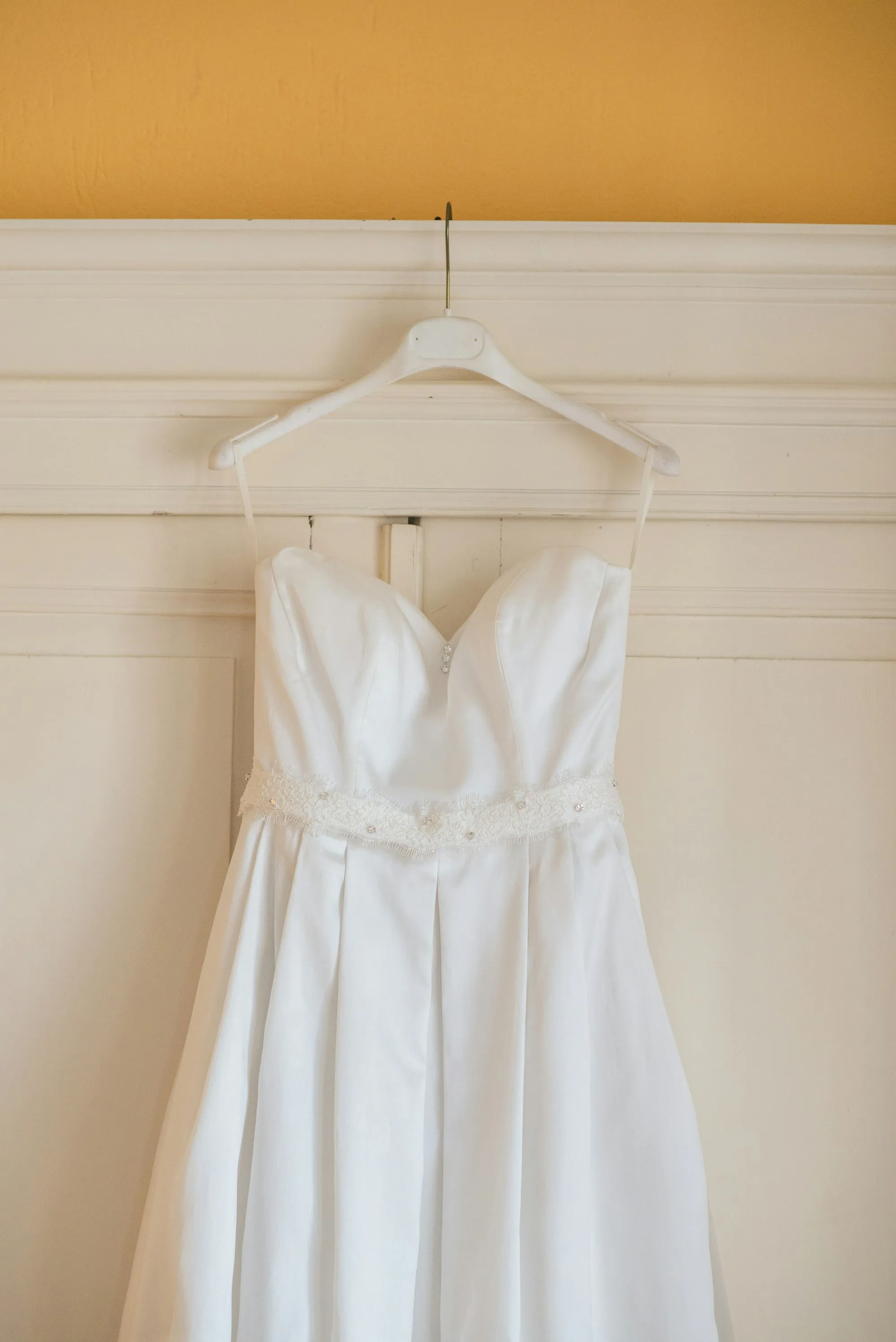Strapless wedding dress hanging on a wall