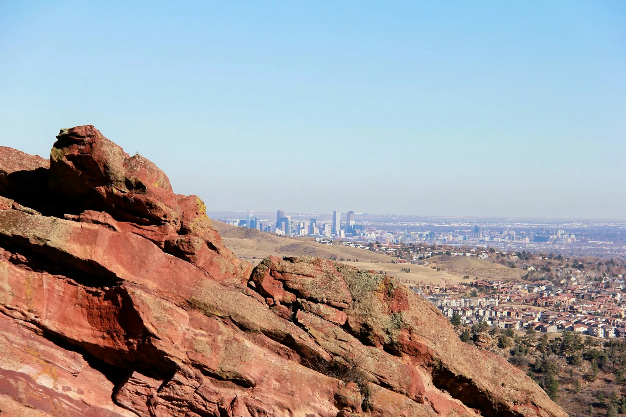 Red sandstone rocks near Red Rocks Park with the Denver skyline in the distance